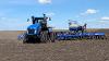 A New Holland Agriculture tractor and seeder in action.